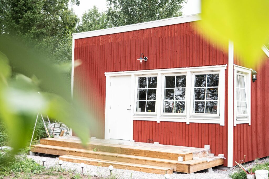 Rött attefallshus med veranda levererat till kund